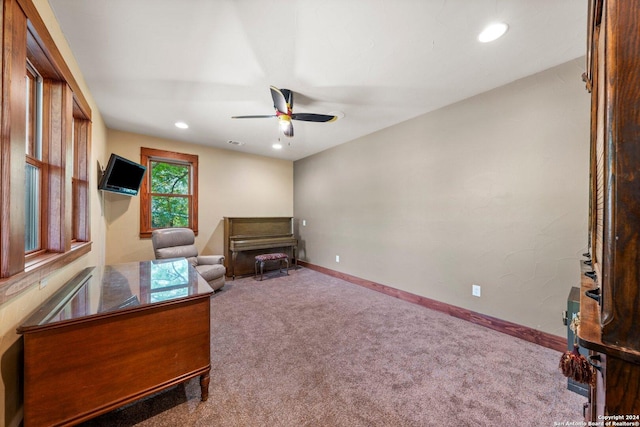 living area with ceiling fan and carpet