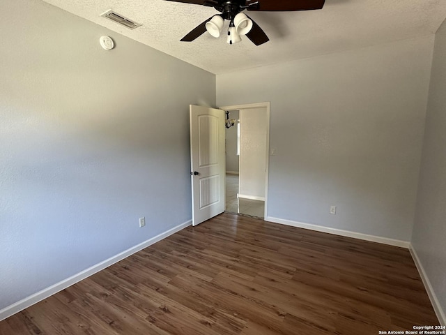 spare room with ceiling fan and dark wood-type flooring