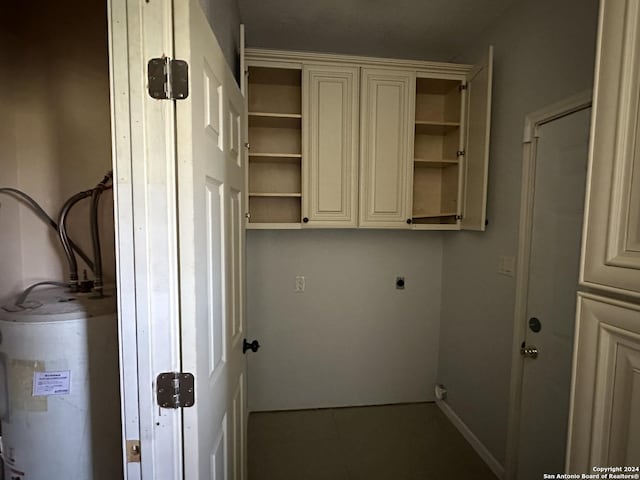 washroom with cabinets, electric dryer hookup, and water heater