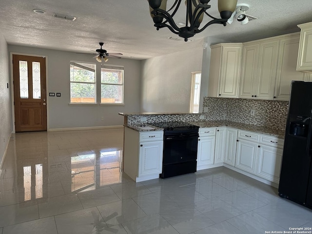 kitchen featuring dark stone countertops, a textured ceiling, decorative backsplash, black appliances, and ceiling fan with notable chandelier