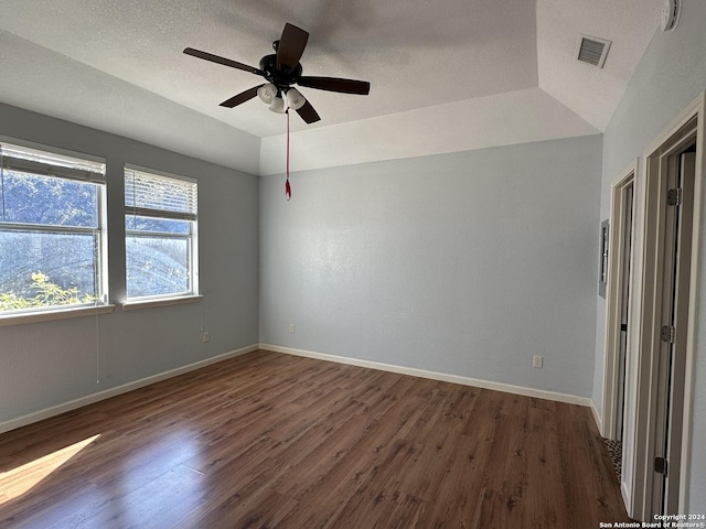 interior space featuring a tray ceiling, ceiling fan, dark wood-type flooring, and a textured ceiling