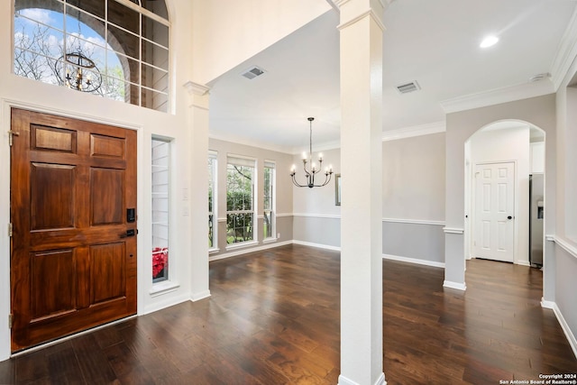 entryway with dark wood-type flooring, a chandelier, and ornamental molding