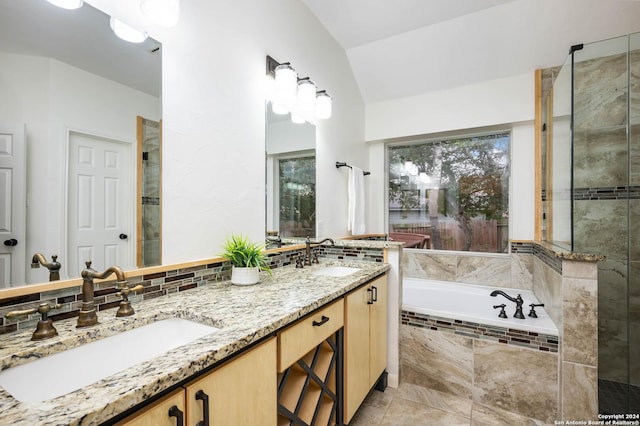 bathroom with tiled tub, tile patterned flooring, vanity, and vaulted ceiling