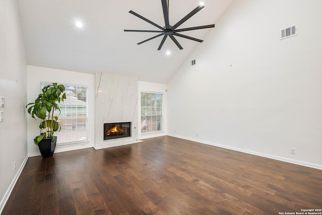 unfurnished living room featuring ceiling fan, dark hardwood / wood-style flooring, a fireplace, and high vaulted ceiling