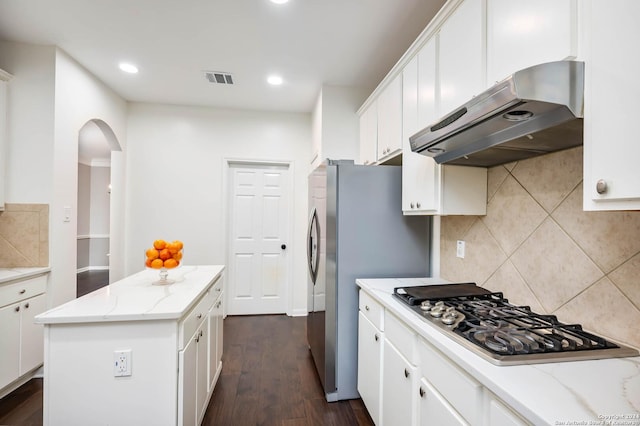 kitchen featuring white cabinets, a kitchen island, light stone counters, and appliances with stainless steel finishes