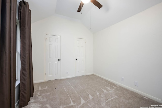 unfurnished bedroom featuring light carpet, ceiling fan, and lofted ceiling