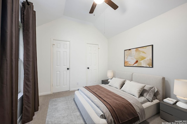 carpeted bedroom with two closets, ceiling fan, and lofted ceiling