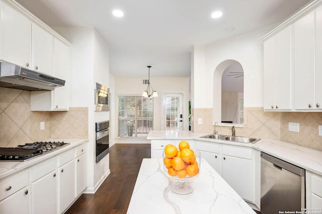 kitchen with pendant lighting, sink, dark hardwood / wood-style floors, appliances with stainless steel finishes, and white cabinetry