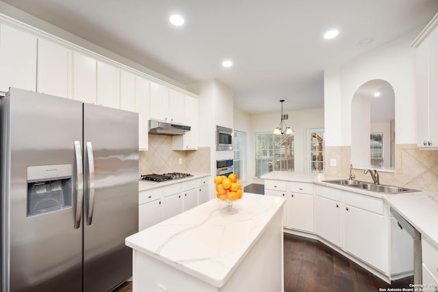 kitchen with white cabinetry, a center island, sink, stainless steel appliances, and pendant lighting