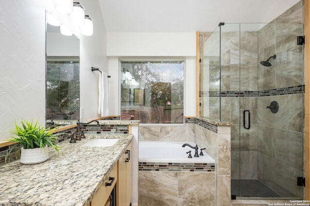 bathroom featuring vanity and independent shower and bath