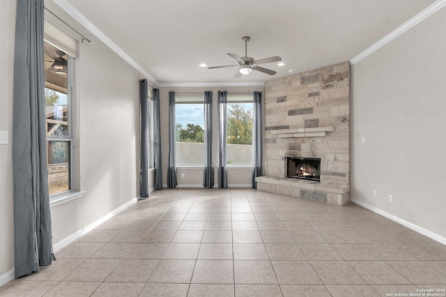 unfurnished living room with a stone fireplace, ceiling fan, crown molding, and light tile patterned floors