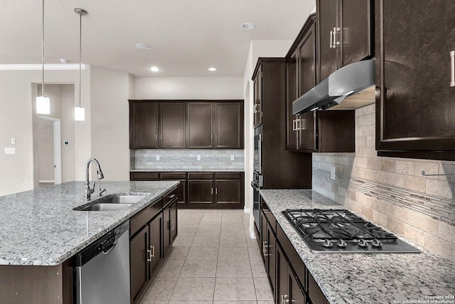 kitchen featuring backsplash, stainless steel appliances, sink, decorative light fixtures, and a center island with sink