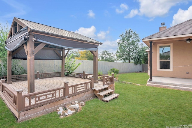 wooden terrace with a gazebo and a lawn