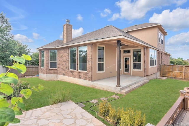 rear view of property with a yard, a patio, and ceiling fan