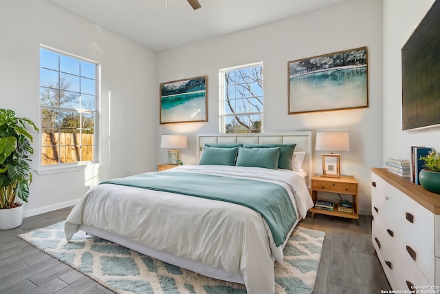 bedroom with multiple windows, ceiling fan, and dark hardwood / wood-style flooring