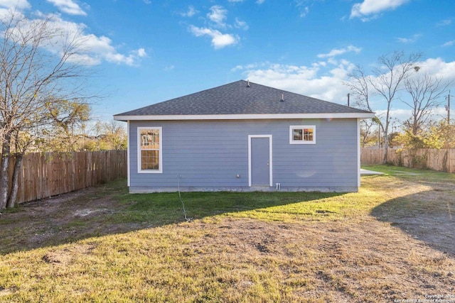 rear view of property featuring a lawn