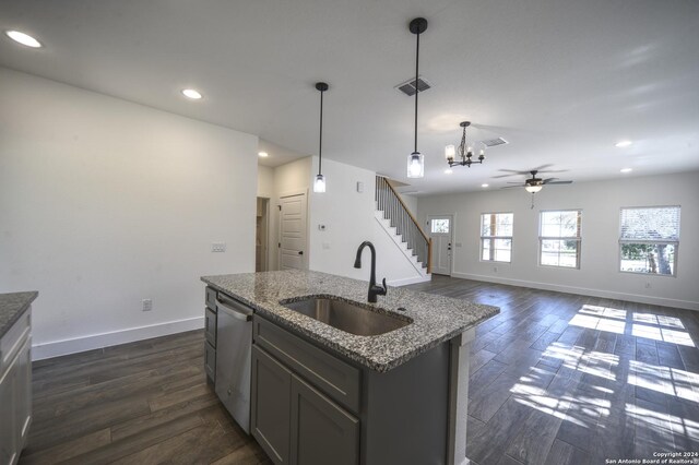 kitchen with dark hardwood / wood-style flooring, sink, dishwasher, hanging light fixtures, and an island with sink