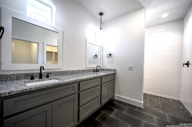 bathroom featuring a tile shower and vanity