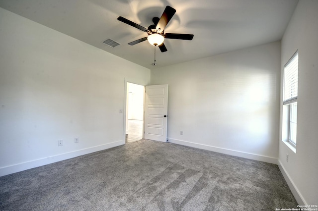 unfurnished room featuring ceiling fan and dark carpet