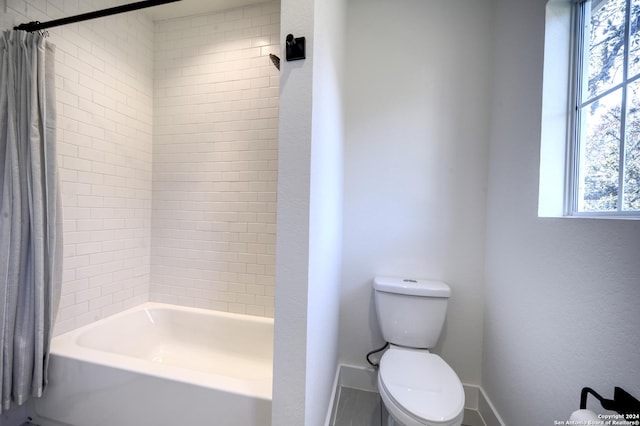 bathroom featuring toilet and shower / bathtub combination with curtain