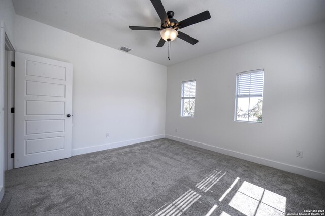 carpeted spare room featuring ceiling fan