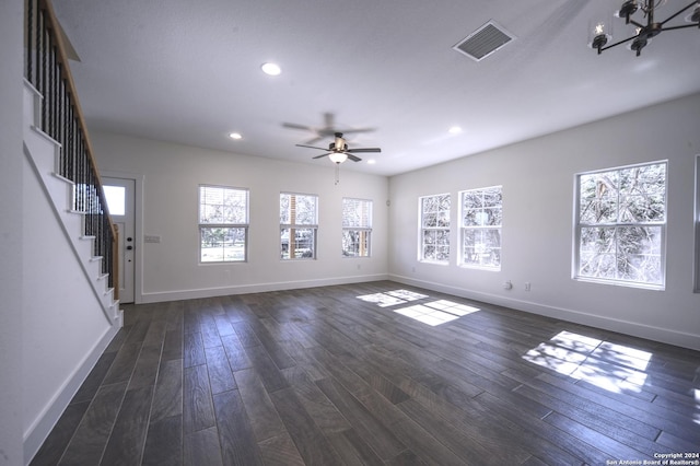 unfurnished living room featuring dark wood-type flooring and ceiling fan with notable chandelier