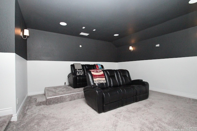 carpeted cinema room featuring vaulted ceiling