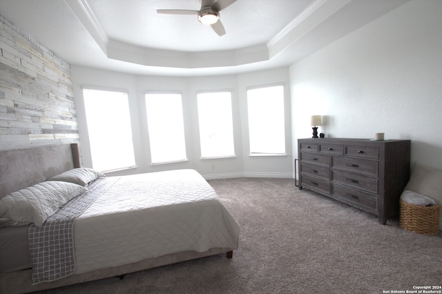 bedroom with a tray ceiling, ceiling fan, ornamental molding, and light colored carpet