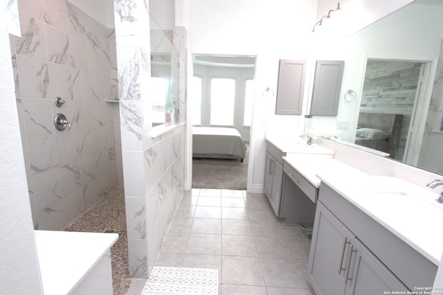 bathroom featuring tile patterned flooring, vanity, and a tile shower