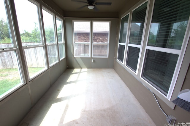 unfurnished sunroom with ceiling fan