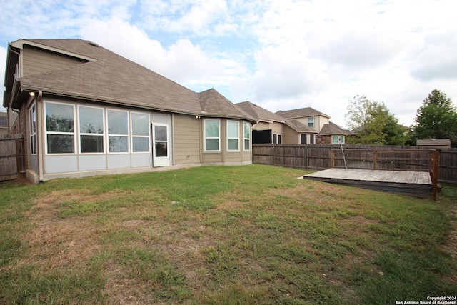 rear view of property with a lawn and a deck