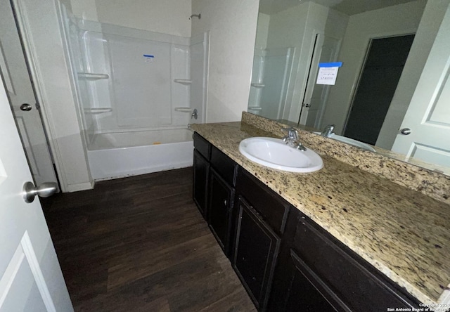 bathroom with bathtub / shower combination, hardwood / wood-style floors, and vanity