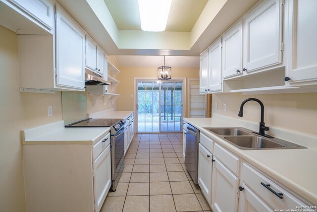 kitchen featuring white cabinets, a raised ceiling, sink, decorative light fixtures, and stainless steel appliances