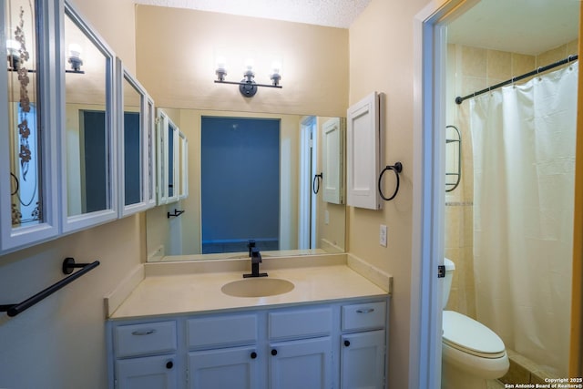 bathroom featuring vanity, a shower with shower curtain, a textured ceiling, and toilet