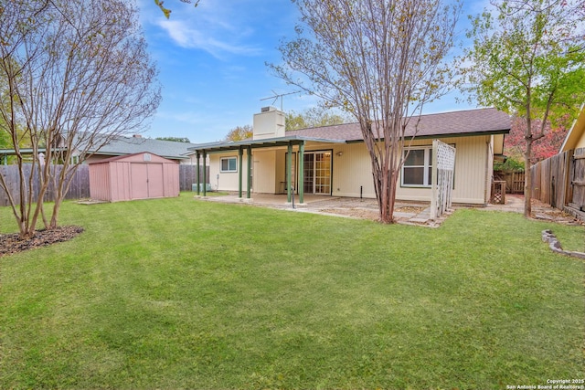 rear view of property featuring a patio, a shed, and a lawn