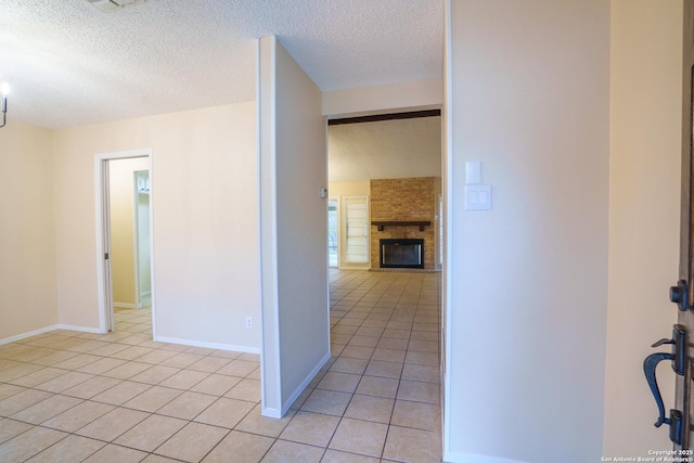 corridor featuring light tile patterned floors and a textured ceiling