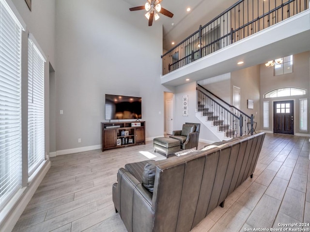 living room with ceiling fan and a high ceiling