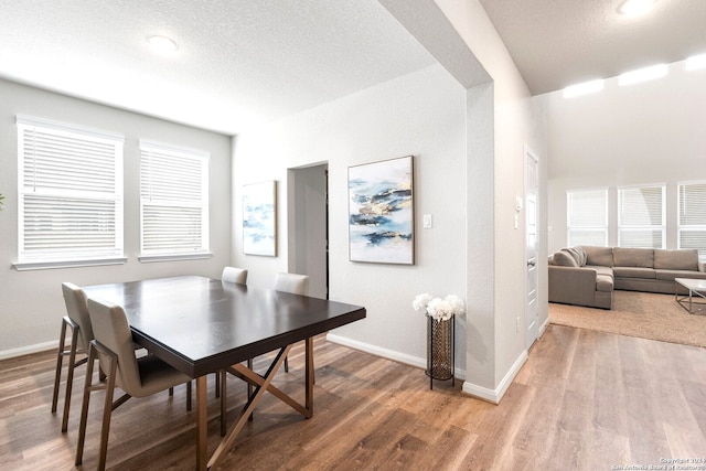 dining area featuring hardwood / wood-style floors and a textured ceiling