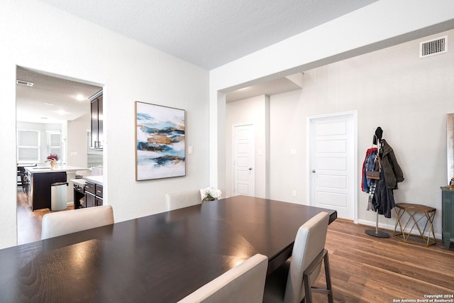 dining room with a textured ceiling and dark wood-type flooring