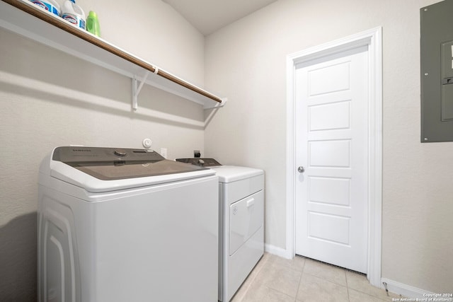 laundry room with washing machine and dryer, electric panel, and light tile patterned floors