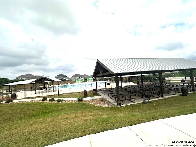 view of property's community with a lawn and a swimming pool