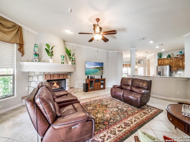 tiled living room with ceiling fan, ornamental molding, and a fireplace