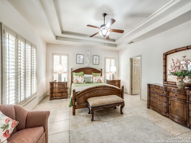 bedroom featuring a tray ceiling, multiple windows, ceiling fan, and light tile patterned floors