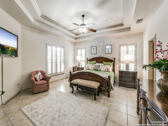 tiled bedroom with ceiling fan, crown molding, multiple windows, and a tray ceiling