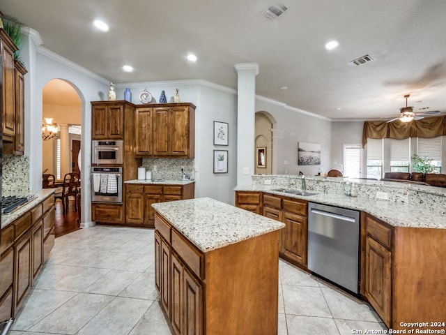 kitchen featuring kitchen peninsula, appliances with stainless steel finishes, backsplash, sink, and a center island