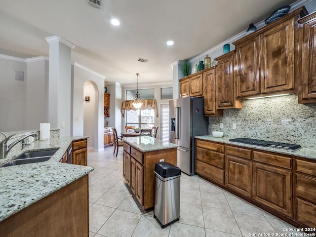 kitchen featuring light stone countertops, sink, a center island, appliances with stainless steel finishes, and ornamental molding