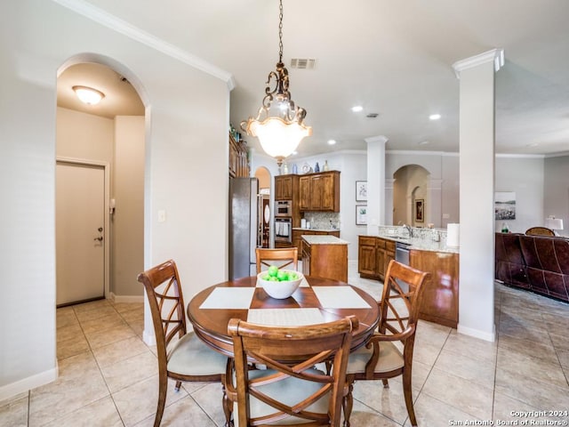 dining space featuring sink, decorative columns, crown molding, and light tile patterned flooring