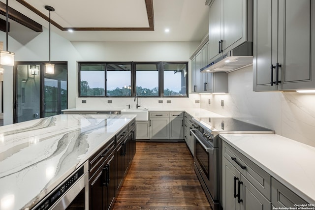 kitchen featuring gray cabinetry, dark wood-type flooring, sink, decorative light fixtures, and stainless steel stove