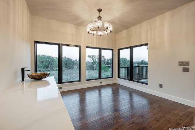 unfurnished room with dark wood-type flooring and an inviting chandelier