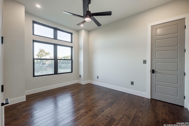 spare room with dark hardwood / wood-style flooring and ceiling fan